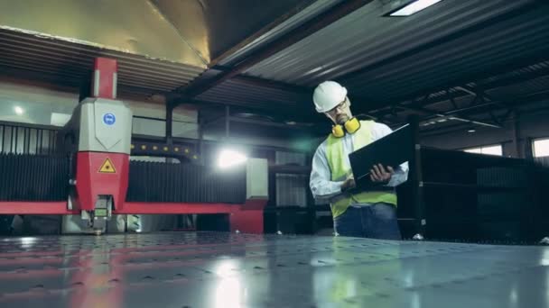 Lasersnijder wordt in de gaten gehouden door een fabriekstechnicus — Stockvideo