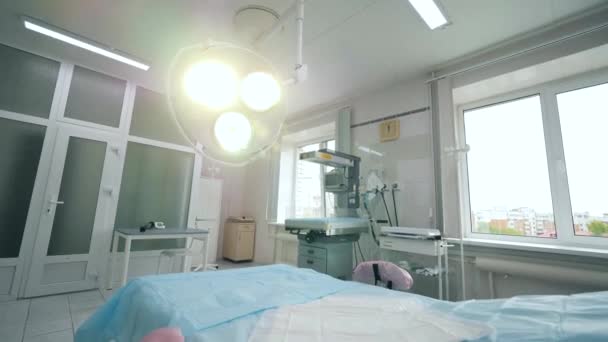 Включенная хирургическая лампа в современной больничной палате — стоковое видео
