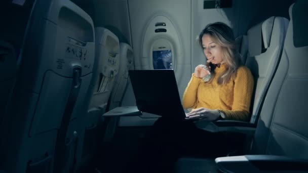 一名年轻女子驾驶手提电脑的飞机在夜间飞行 — 图库视频影像