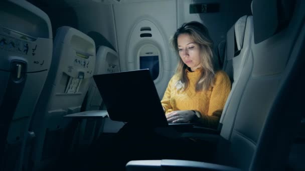 Cabine d'avion la nuit avec une dame utilisant un ordinateur portable — Video