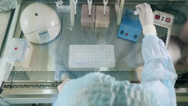 医学研究者は生化学的解析を行っている。研究室でコロナウイルスのサンプルを扱う科学者. — ストック動画