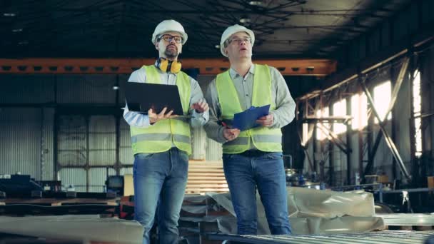 Unidade de fábrica de metal com técnicos masculinos inspecionando-o — Vídeo de Stock