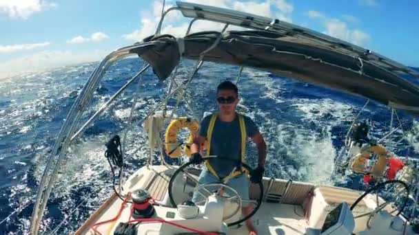 A boat is being navigated by a handsome man — Stockvideo