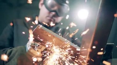Sparks from cutting metal are hitting the camera