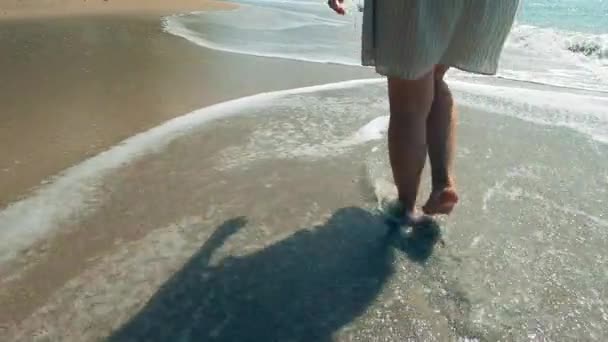 As pernas femininas são mostradas enquanto caminham ao longo do litoral — Vídeo de Stock