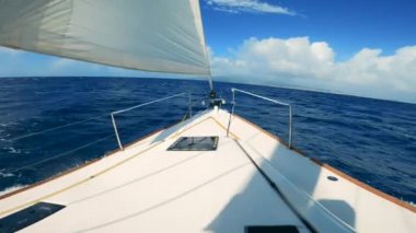 First-person view from a yacht sailing across the sea. Sailing boats in blue ocean waters ina sunny day.