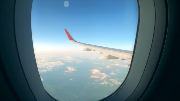 Крыло самолета видно через окно во время полета — стоковое видео