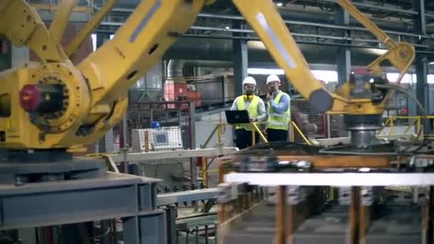 Unidad de planta mecánica e ingenieros masculinos que la supervisan — Vídeo de stock