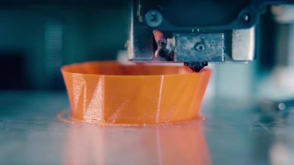 Drukarka 3D produkuje pomarańczowy obiekt. Drukarka 3D pracująca w drukarni 3D. — Wideo stockowe