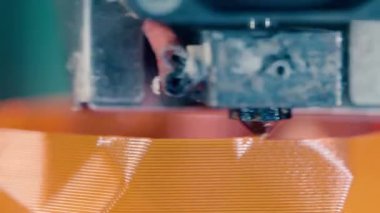 3D baskı laboratuvarında çalışan 3D yazıcı. Turuncu plastik katmanlar 3d yazdırılıyor