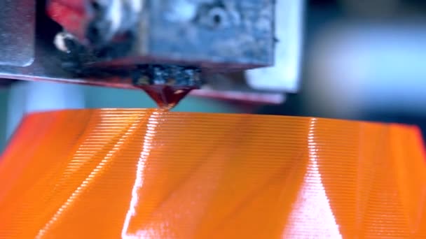 La tête d'une imprimante 3D crée de fines couches orange. Imprimante 3D travaillant au laboratoire d'impression 3D . — Video