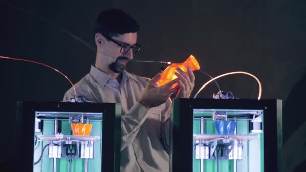 Mužský expert pozoruje vázu vedle 3D tiskáren — Stock video
