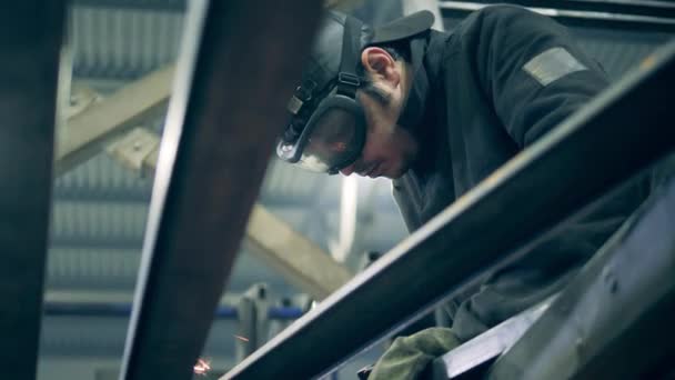 Male welder in safety wear is cutting steel — 图库视频影像