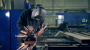 Welding technician is brazing pieces of metal. Professional Welder Working at factory facility.