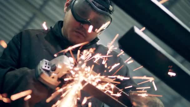 Um pedaço de um feixe de metal está sendo cortado com muitas faíscas — Vídeo de Stock