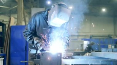 Professional Welder Working at factory facility. Welding technician in safety wear at work in a factory