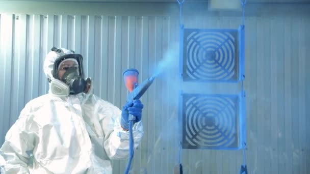 Proceso de pintura industrial en las instalaciones de la fábrica de pintura. Técnico en desgaste de seguridad está muriendo piezas de metal azul — Vídeos de Stock