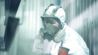 Metal boyarken kadın işçilerin yüzlerini güvenlik önlemi için kapatın. Boyama fabrikasında sanayi boyama işlemi.