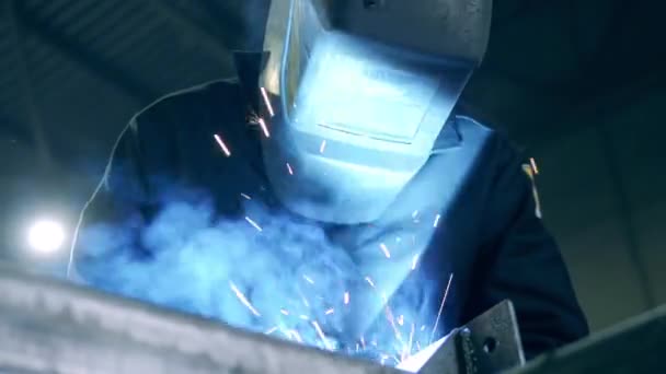 Professional welder in a helmet and sparks caused by welding — 비디오