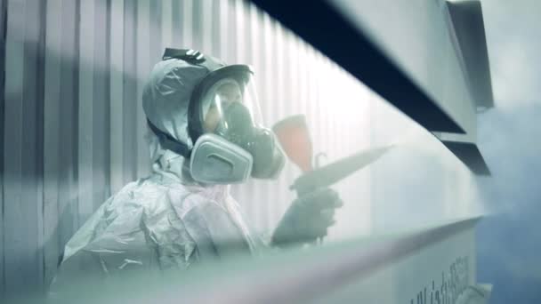 Une femme en tenue de sécurité pulvérise de la peinture sur du métal — Video