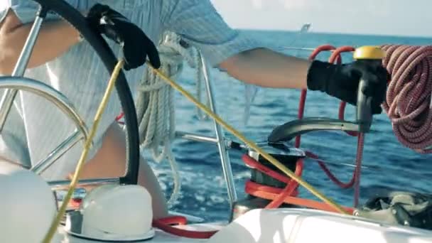 Touwen aan boord van een jacht worden losgetrokken door een vrouw — Stockvideo