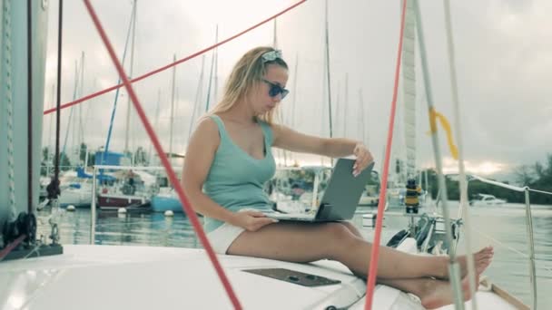 A woman is operating a laptop onboard of a yacht — 비디오