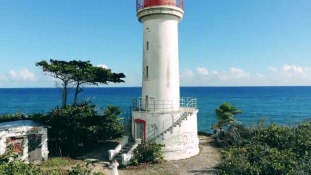 Jedna latarnia morska stojąca na klifie w pobliżu błękitnego morza. — Wideo stockowe