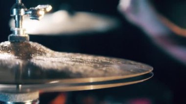 Metal cymbal moving while a man plays.
