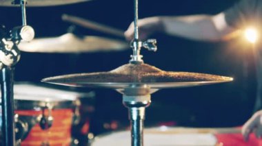 Professional drummer plays drumkit with cymbals.