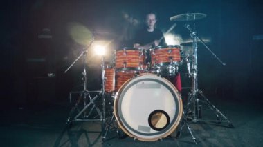 Young drummer plays a drumkit.