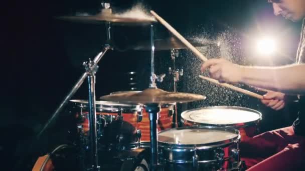 Чоловічий музикант грає на барабанах під час бризок води. Барабанщик грає набір барабанів . — стокове відео