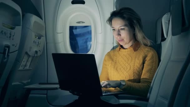 Night flight and a smiling lady working on a laptop during it — 비디오