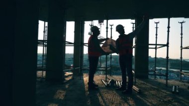 Profesyonel inşaat mühendisleri ve inşaat mimarları inşaat alanında birlikte çalışırlar..