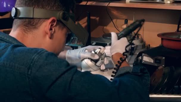 Jeweller, goldsmith uses tools while working with a golden ring. A goldsmith in jewelry working with gold ring and luxury brilliant. — Stockvideo