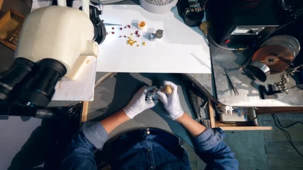 Professional jeweller working with a ring, using tool. A goldsmith in jewelry working with ring. — Stockvideo