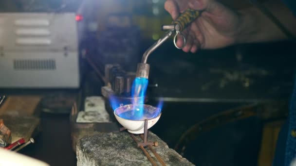 Jeweller melts metal, using a burner in a workshop. — Stock Video