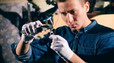Jeweler measures a diamond on a ring.