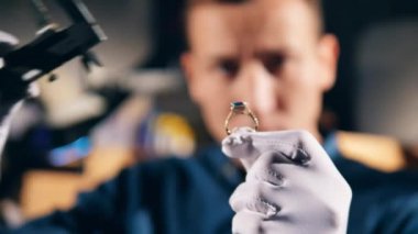 Jeweller, goldsmith measures a gemstone on a ring.