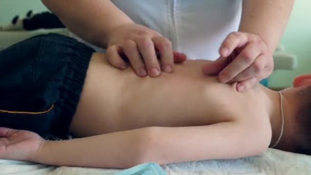 Ein professioneller Masseur massiert Rücken und Schultern der Kinder. — Stockvideo