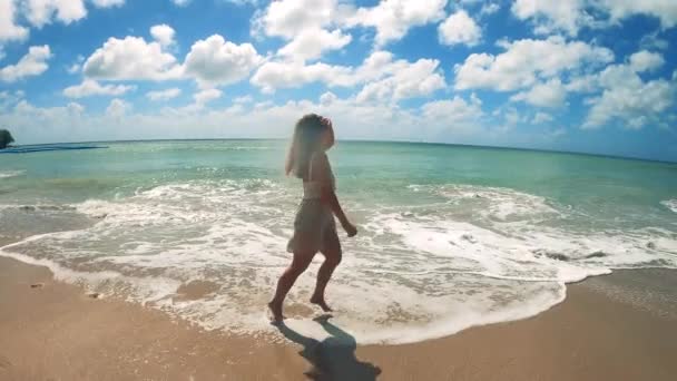 Vacker kvinna springer sakta längs stranden — Stockvideo