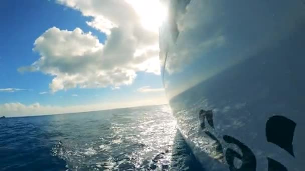 Boční pohled na jachty deska s oblohou a moře odrážející se v něm — Stock video