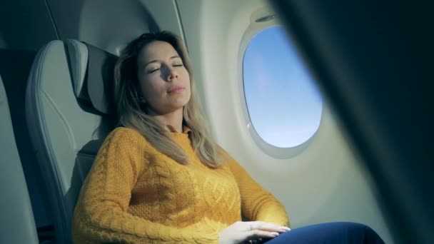 La mujer dormida está sentada junto a una ventana durante el vuelo. — Vídeos de Stock
