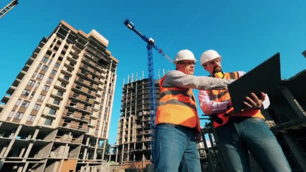 Ingénieurs professionnels de la construction, architectes de la construction travaillent sur un chantier avec un ordinateur portable . — Video