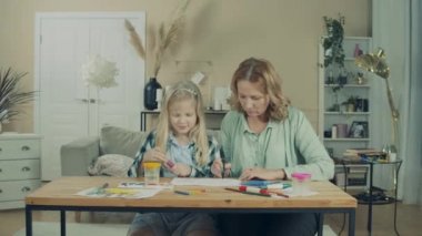 Granny and little girl are having fun while drawing