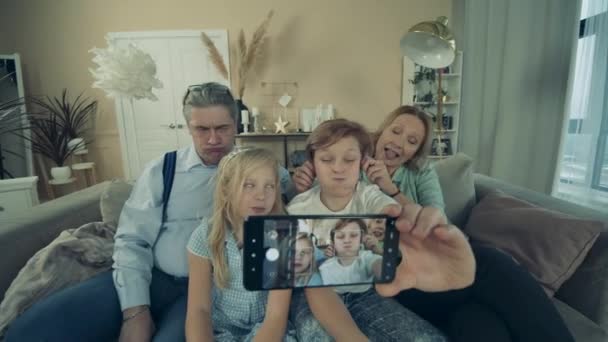 Los niños pequeños y sus abuelos se están tomando una selfie en casa — Vídeos de Stock