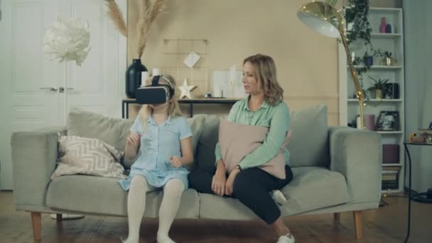 Бабушка играет с маленькой девочкой в VR-очках — стоковое видео