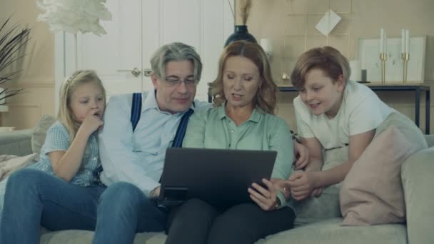 Mamie et grand-père s'amusent avec les petits-enfants et l'ordinateur portable — Video