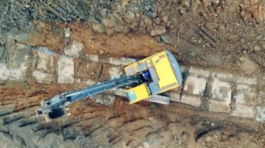 Tractor uses backhoe while working at a quarry.