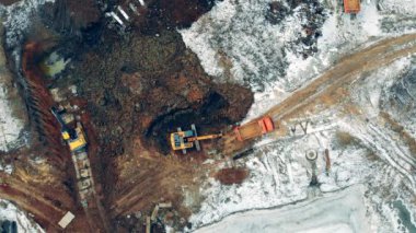 Industrial machinery working at a construction site. Many machines work with earth at a quarry. Construction excavator work at the industrial quarry.