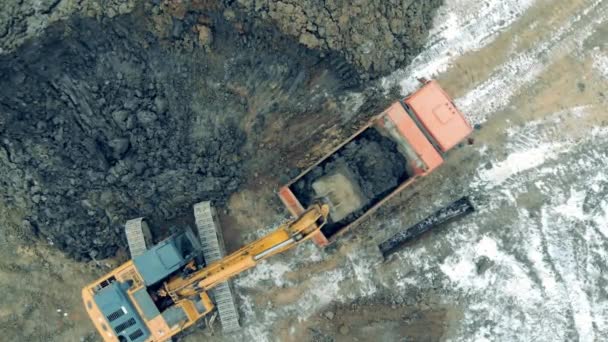 Working excavator loads a truck with stones at a career. Construction excavator work at the industrial quarry. — Stok video